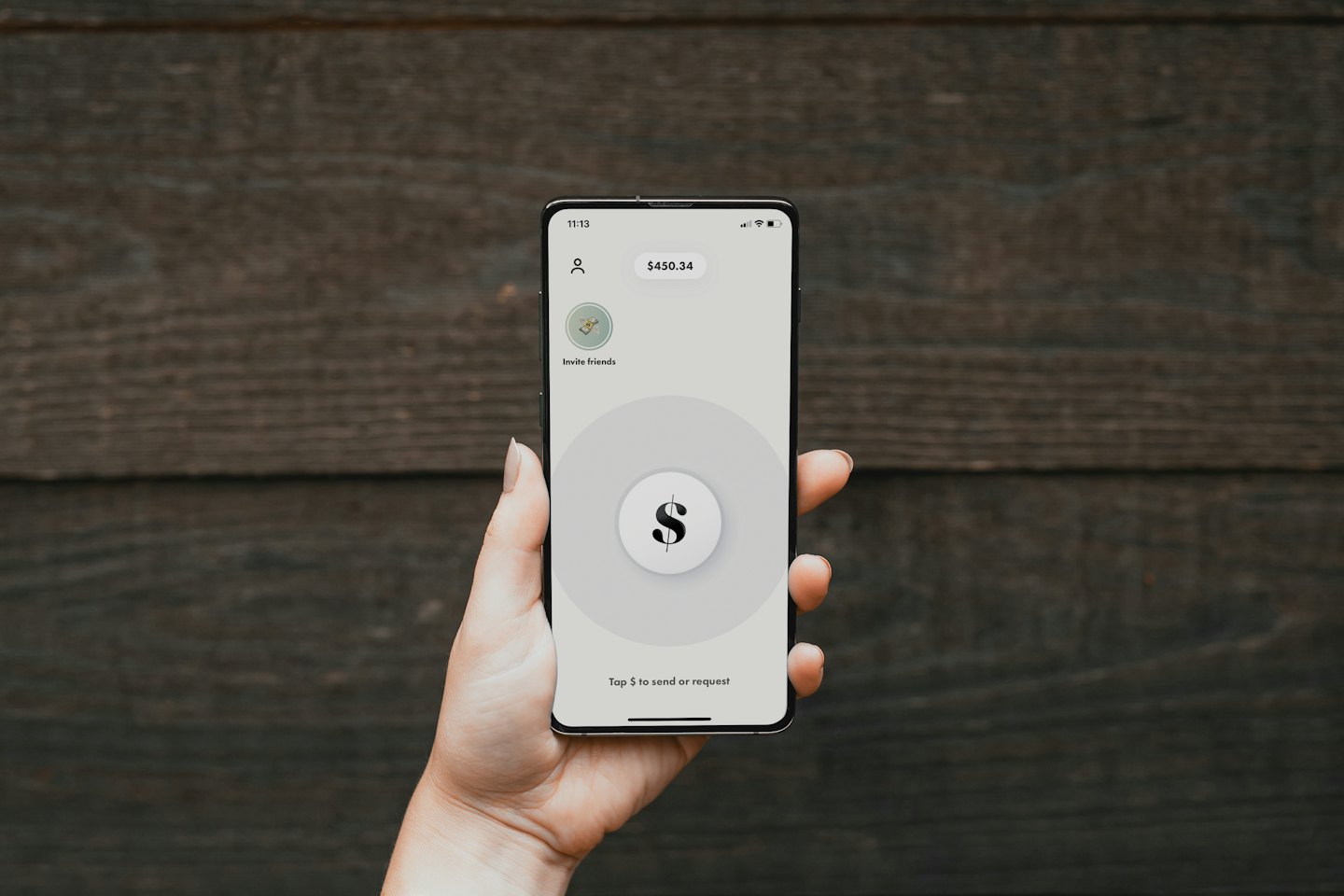 Dłoń trzymająca smartfon z widoczną aplikacją płatności mobilnych.